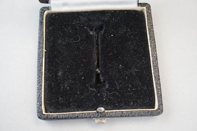 A black velvet box with a letter i in it

Description automatically generated