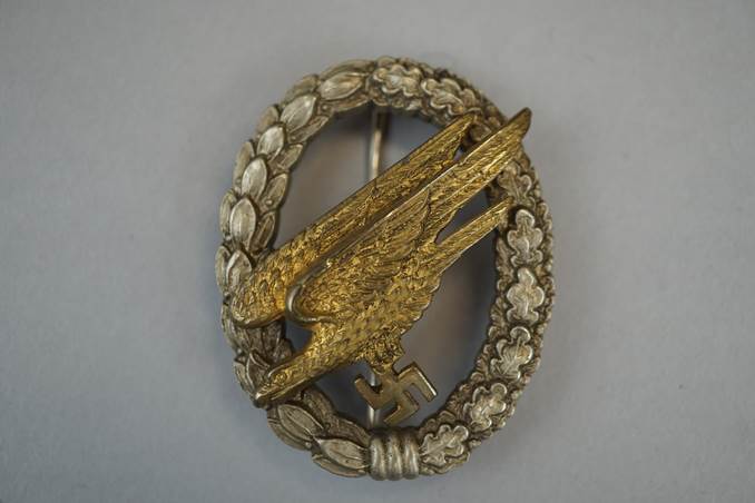 A gold eagle in a wreath

Description automatically generated