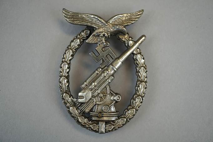 A metal badge with an object and a eagle

Description automatically generated