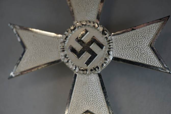 A close-up of a silver cross

Description automatically generated