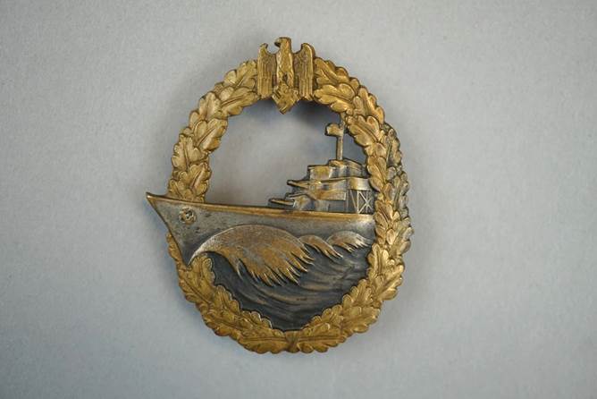 A gold and silver emblem with a ship in the water

Description automatically generated