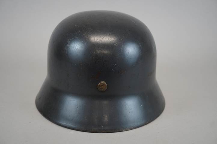 A black metal helmet with a screw

Description automatically generated