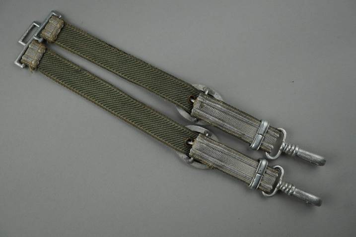 A pair of green straps with metal clasps

Description automatically generated