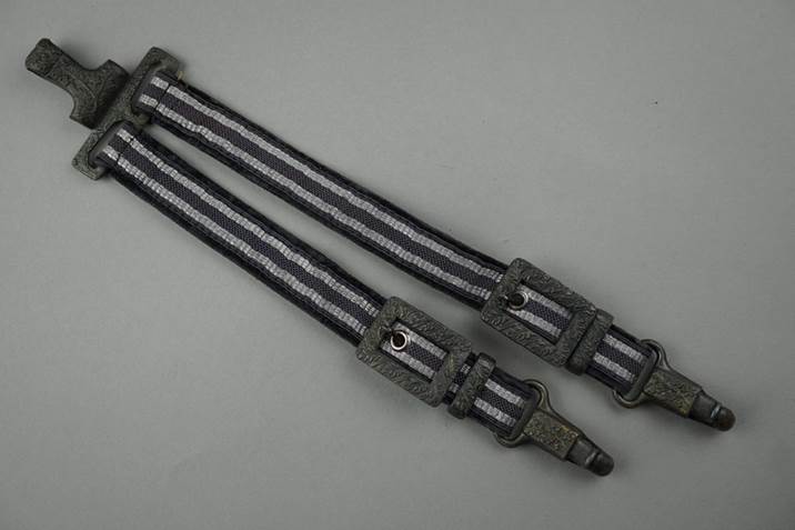 A pair of straps with a metal buckle

Description automatically generated