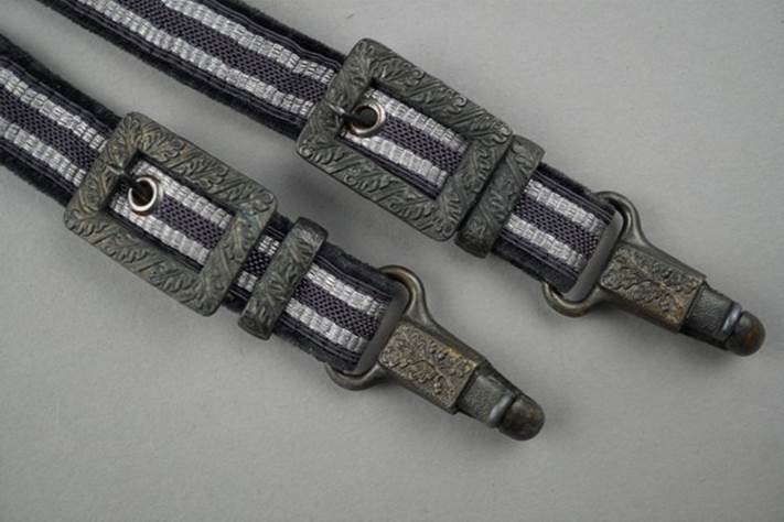 A pair of straps with metal clasps

Description automatically generated