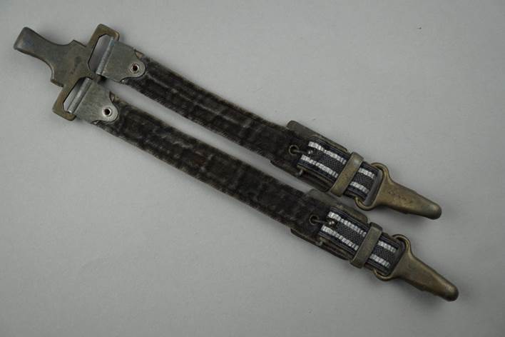 A pair of black straps with metal clasps

Description automatically generated