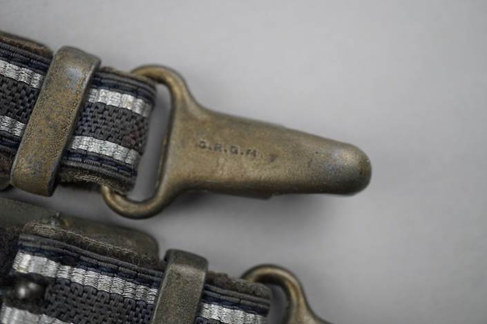 A metal clasp on a strap

Description automatically generated