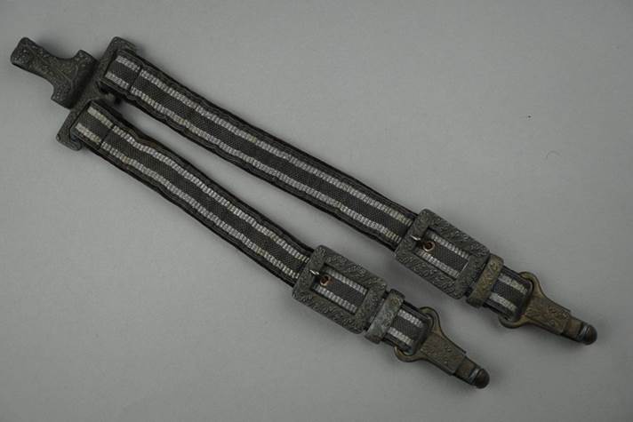 A pair of straps with metal buckles

Description automatically generated