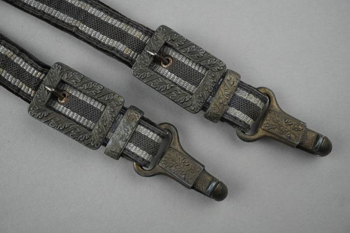 A pair of belts with metal buckles

Description automatically generated