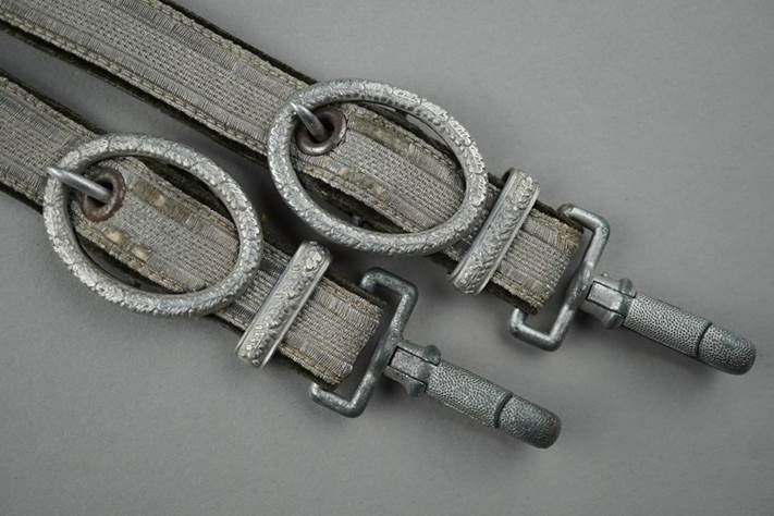 A pair of grey straps with metal rings

Description automatically generated