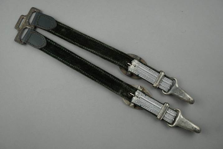 A pair of black straps with silver buckles

Description automatically generated