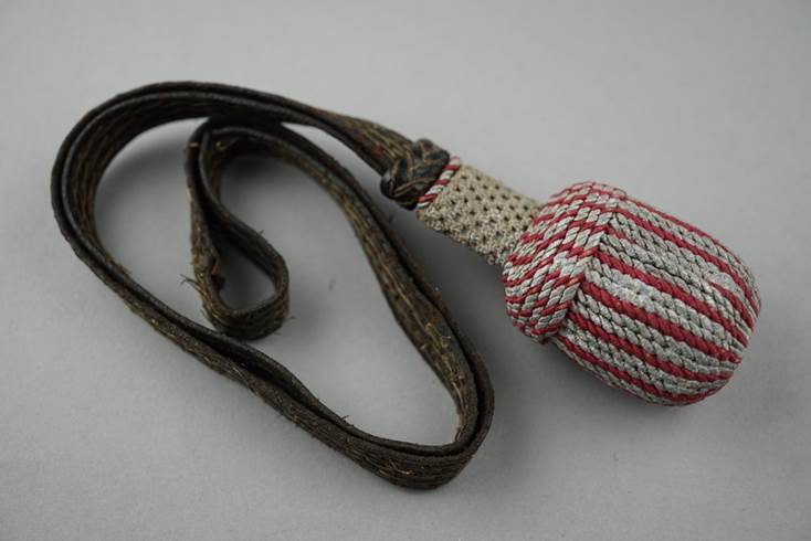 A rope ball on a strap

Description automatically generated