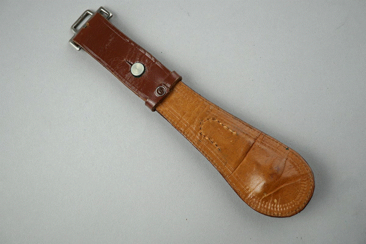 A brown leather strap with a buckle

Description automatically generated