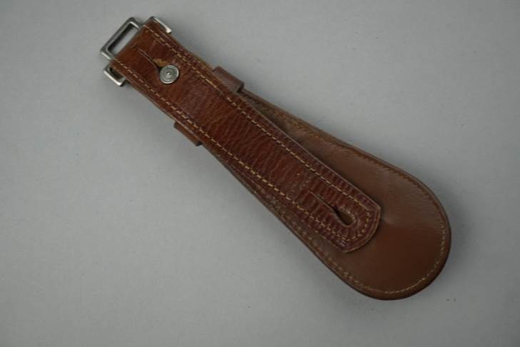 A brown leather strap with a metal buckle

Description automatically generated