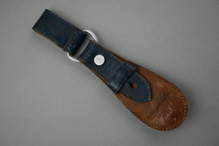 A leather strap with a metal ring

Description automatically generated