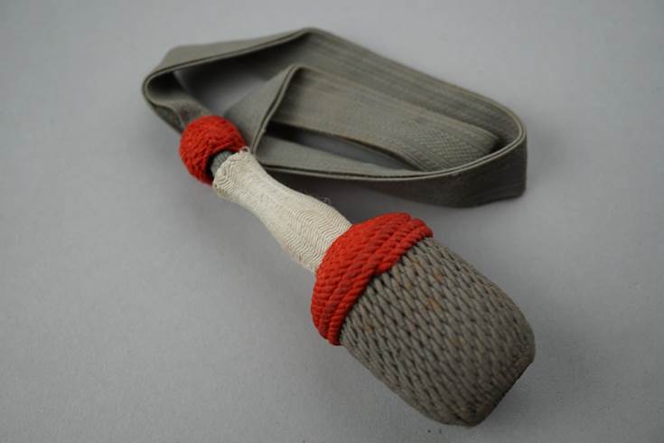 A grey and red rope with a white handle

Description automatically generated