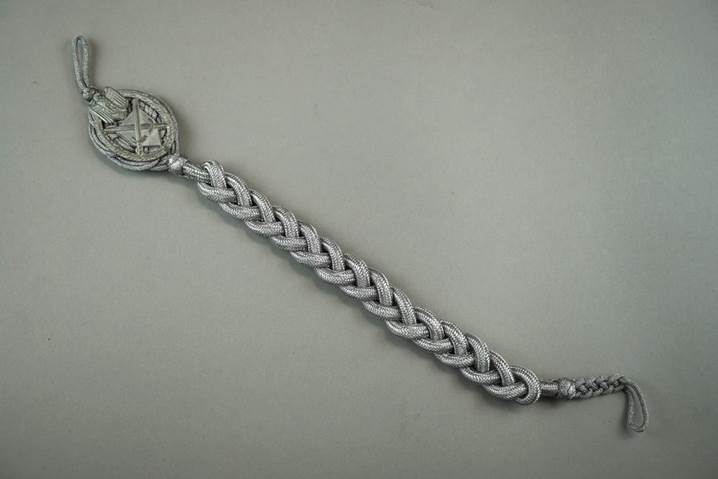 A silver bracelet with a coin

Description automatically generated