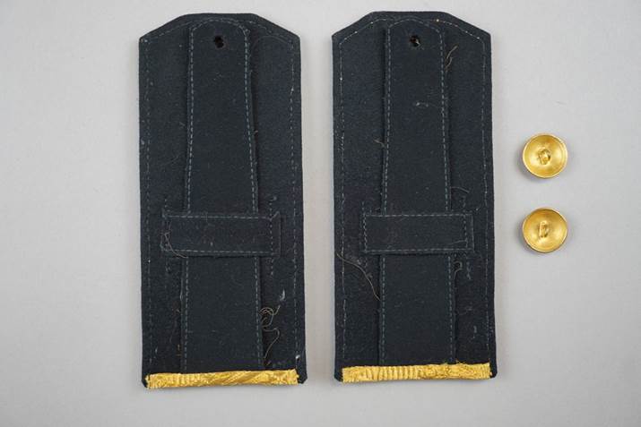 A pair of black straps with gold trim

Description automatically generated