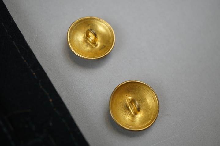 A pair of gold buttons

Description automatically generated