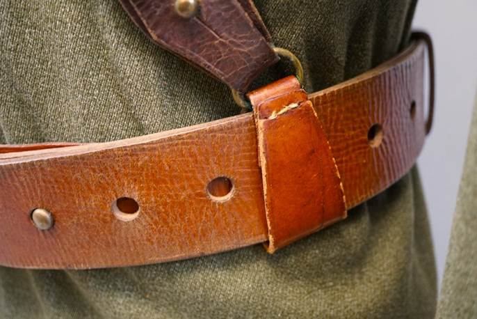 A brown leather belt on a green uniform

Description automatically generated