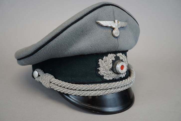 A grey hat with a silver emblem

Description automatically generated
