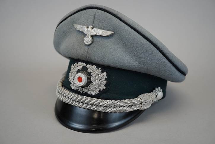 A grey hat with a white and silver emblem

Description automatically generated