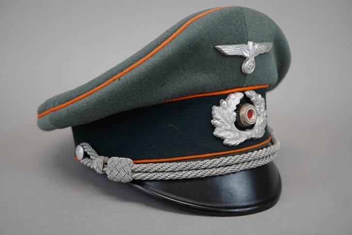 A green hat with a silver emblem

Description automatically generated