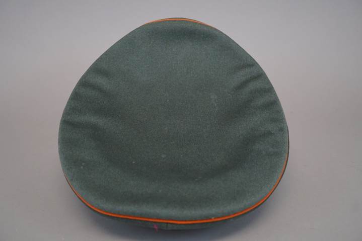 A green hat with orange piping

Description automatically generated