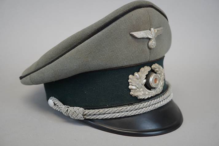 A hat with a silver emblem

Description automatically generated
