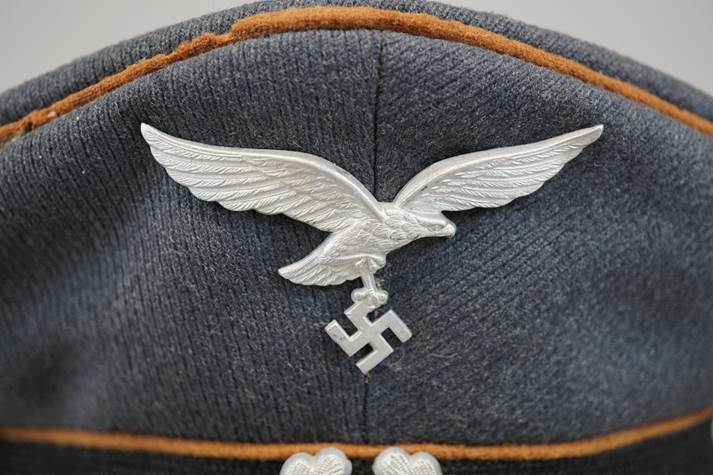 A hat with a white eagle on it

Description automatically generated