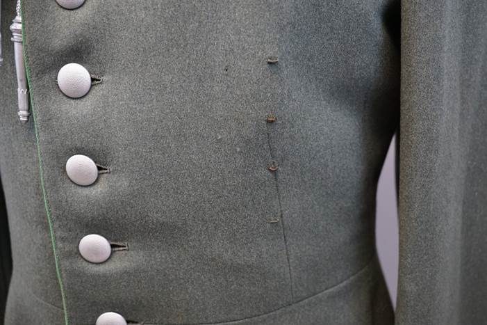 Close-up of a buttoned jacket

Description automatically generated