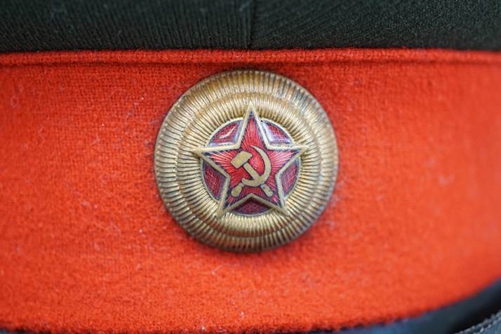 A red hat with a star and hammer and sickle

Description automatically generated