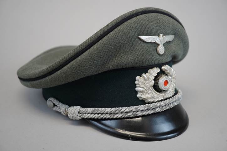 A military hat with a silver emblem

Description automatically generated