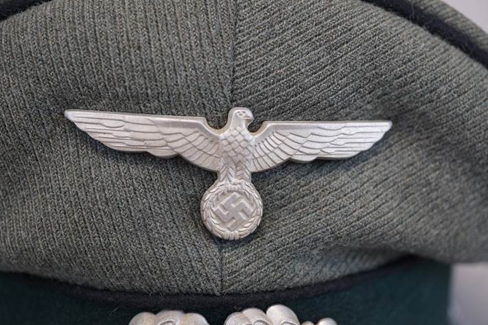 A silver eagle on a military hat

Description automatically generated