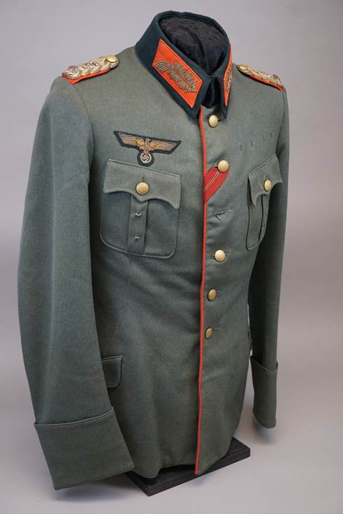 A military uniform with a red and blue patch

Description automatically generated