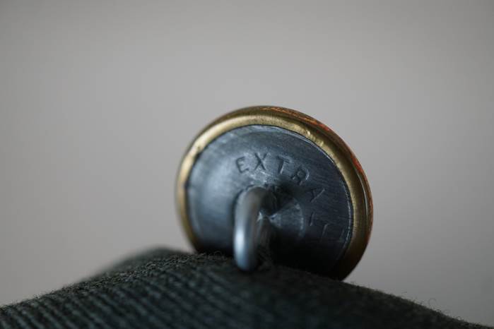 Close-up of a button on a fabric surface

Description automatically generated