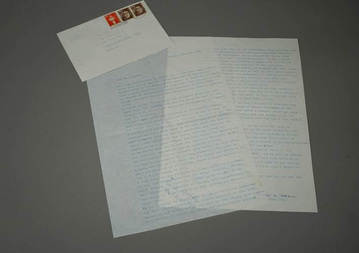 A letter and envelope on a gray surface

Description automatically generated