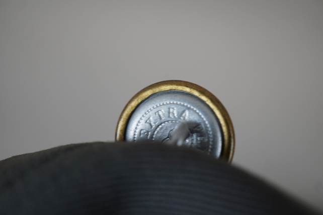 Close-up of a button on a black glove

Description automatically generated