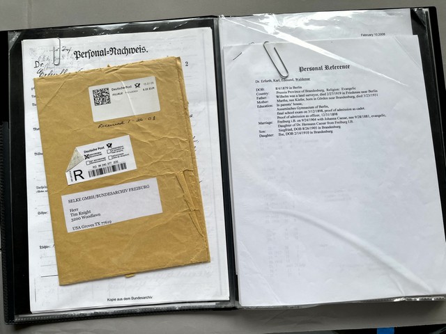 A folder with a paper clip and a brown envelope

Description automatically generated