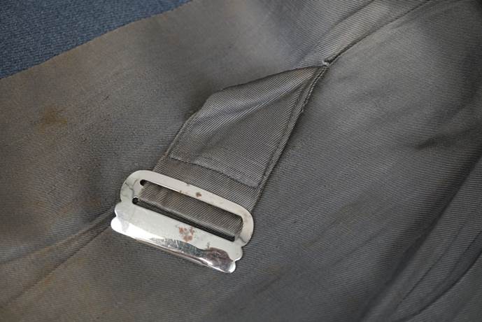 A metal buckle on a piece of fabric

Description automatically generated