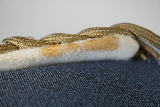 Close-up of a fabric with a yellow cord

Description automatically generated