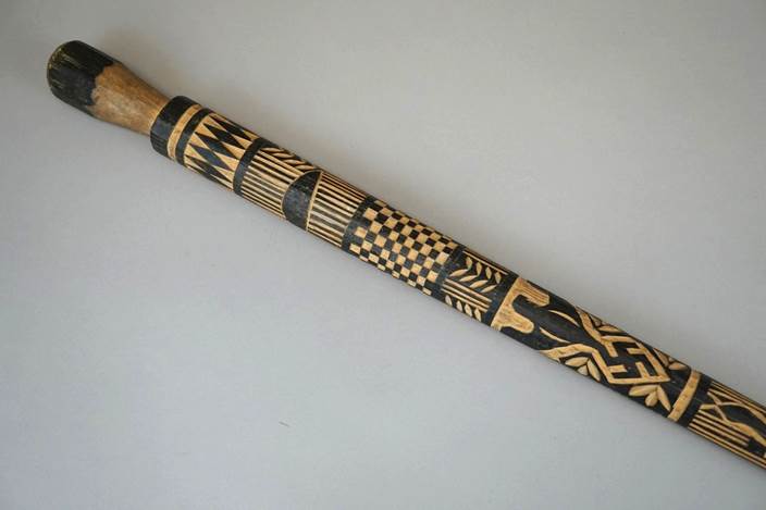 A wooden stick with a design on it

Description automatically generated