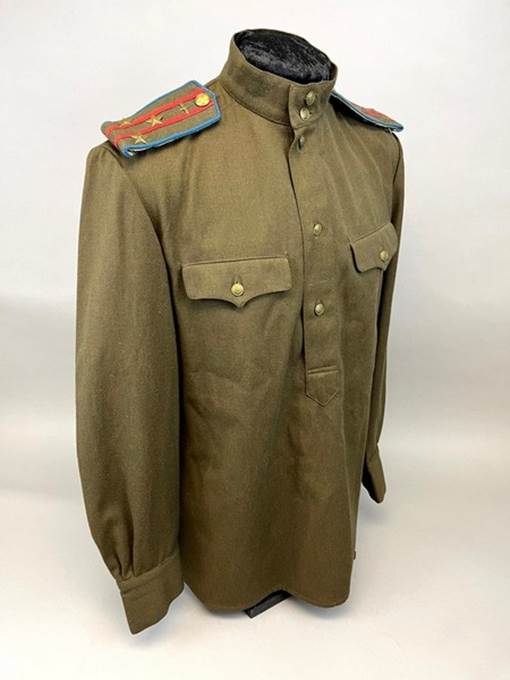 A brown military uniform with a blue and red patch on the shoulder

Description automatically generated