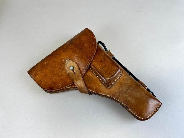 A brown leather holster with a metal handle

Description automatically generated