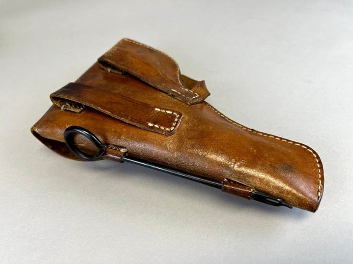 A brown leather holster with a black handle

Description automatically generated