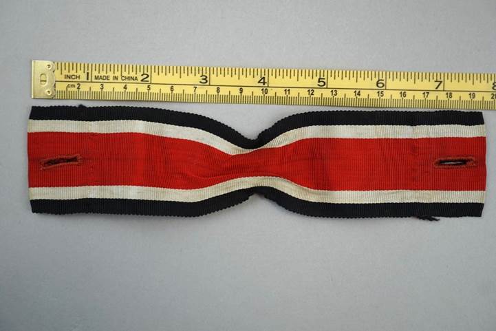 A tape measure and a red white and black ribbon

Description automatically generated