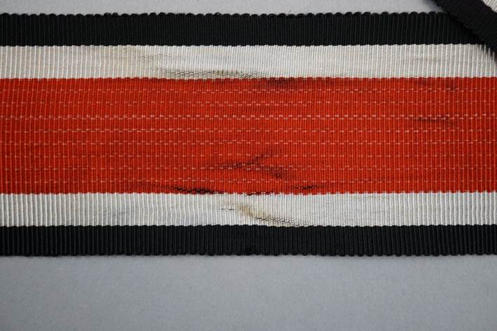 A red and black striped ribbon

Description automatically generated