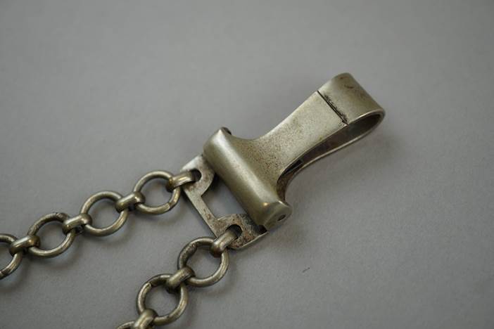 A metal clip on a chain

Description automatically generated