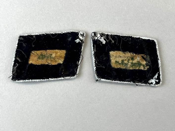 A pair of black patches with white thread

Description automatically generated