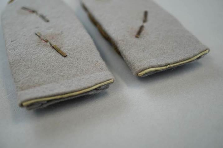 Close-up of a pair of grey felted pads

Description automatically generated